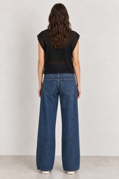 Vista posteriore della modella con Jeans Frida e maglia a rete